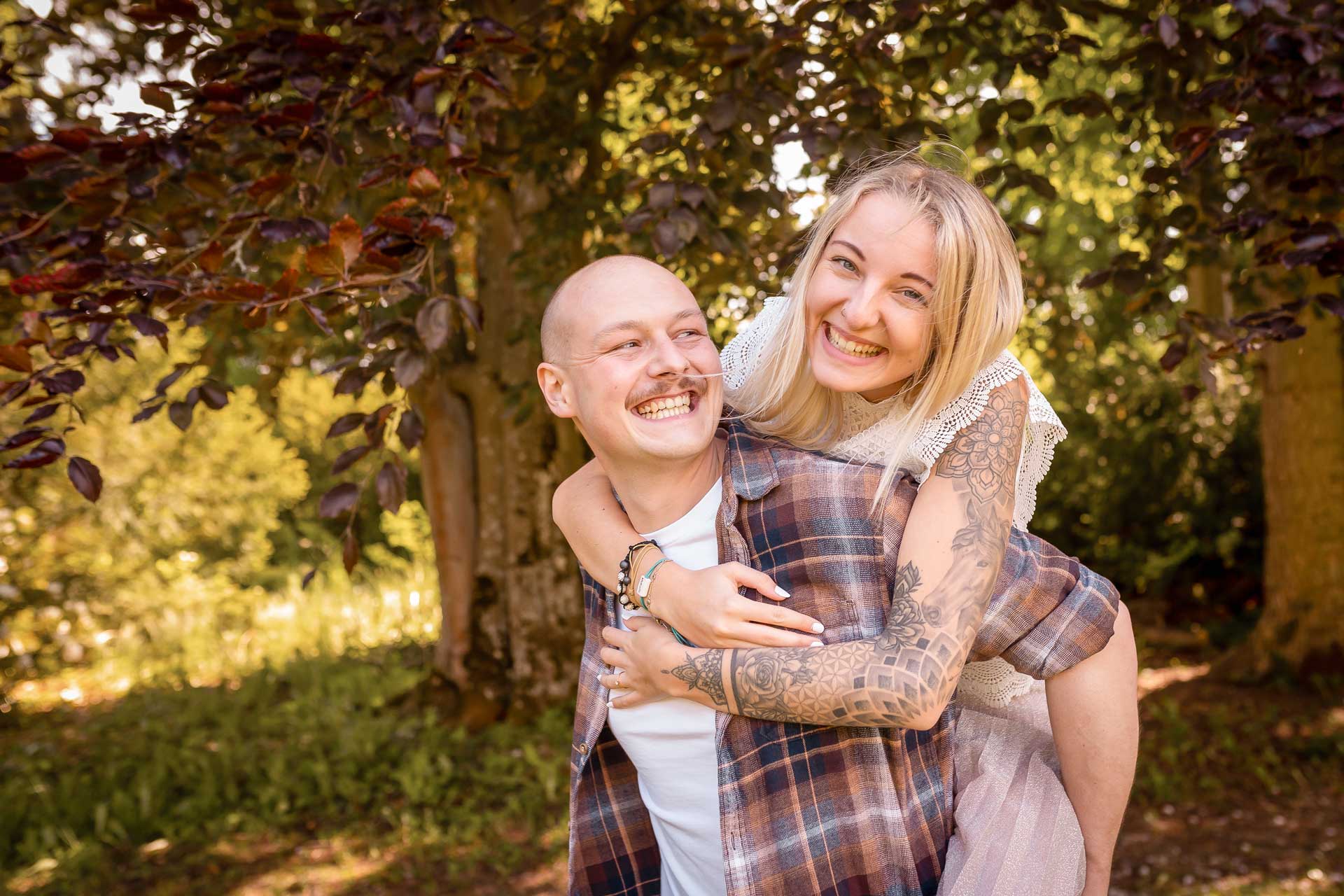 Ein glückliches Pärchen, das in die Kamera lächelt beim Paar Fotoshooting