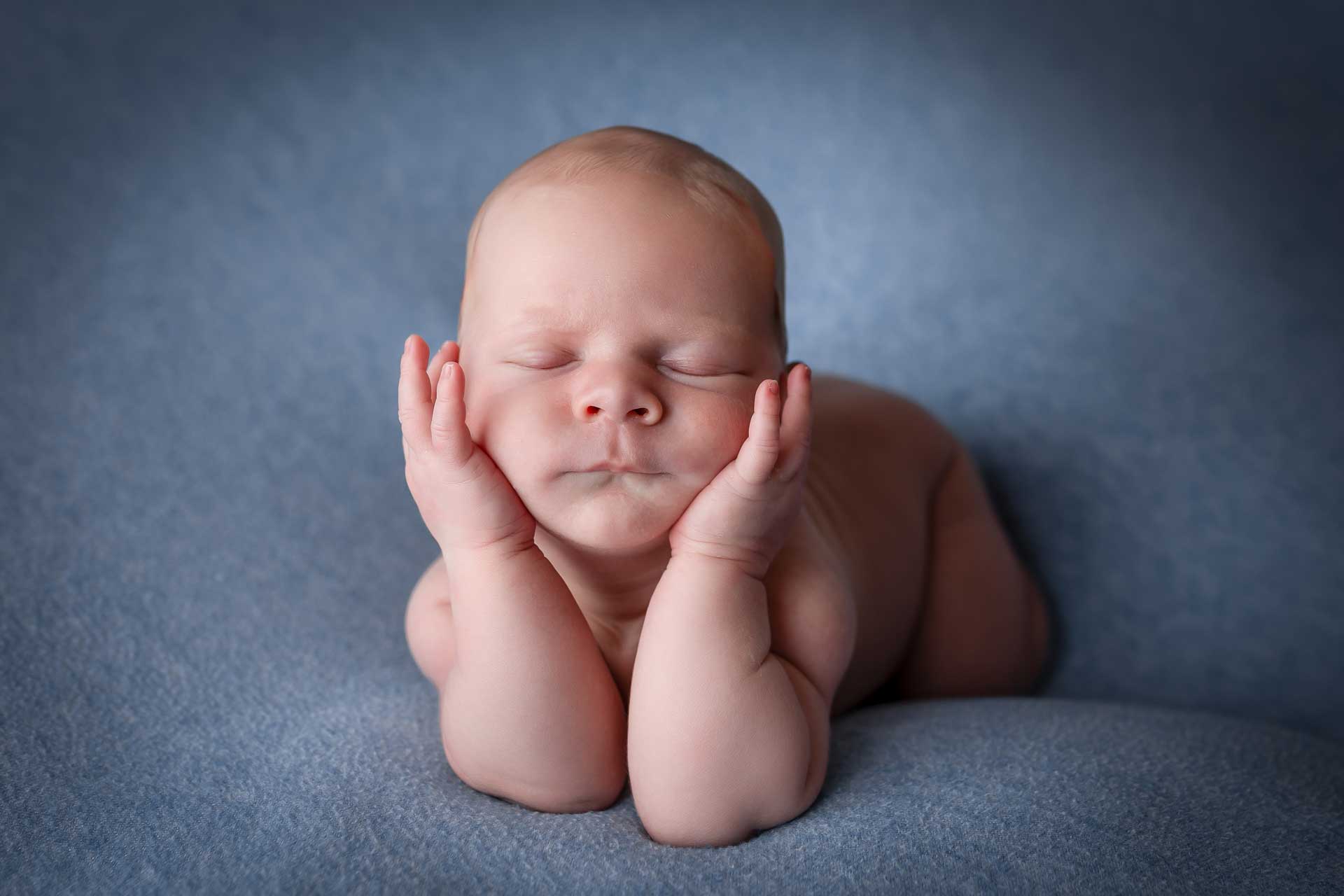 Babyshooting mit Baby, das den Kopf auf die Hände stützt und schläft