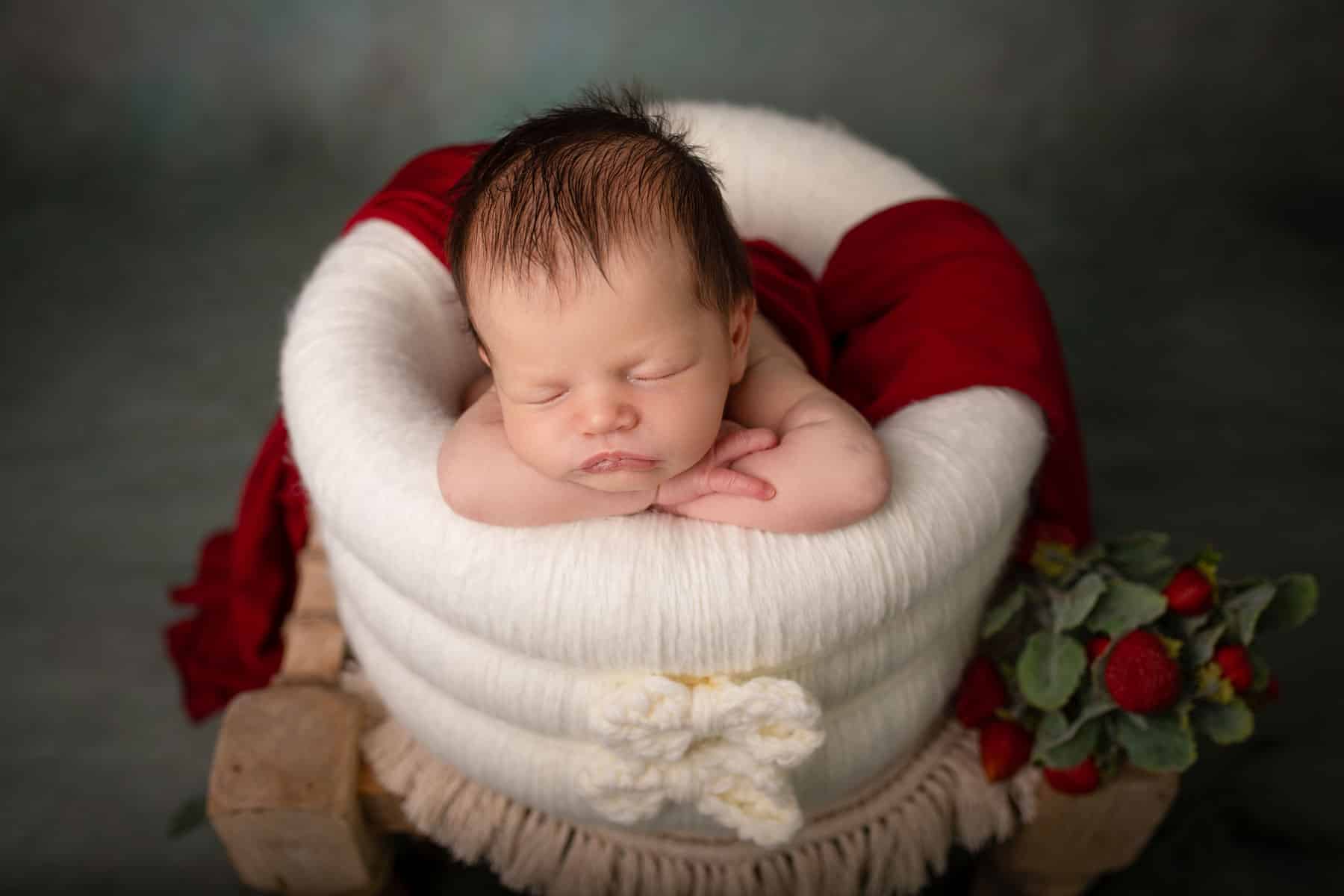 Ein Baby in einem weißen Korb beim Babyshooting